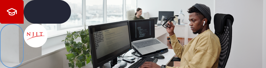 Person working at a desk with multiple monitors in a bright, modern office setting.

